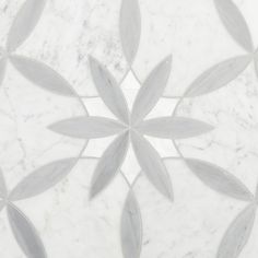 a white marble floor with grey leaves on it