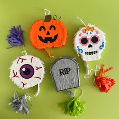 three paper pumpkins with faces on them and one has a tombstone in the middle