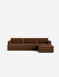 a brown sectional couch sitting on top of a white floor