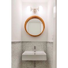 a bathroom with a sink, mirror and tiled walls in the corner is pictured here