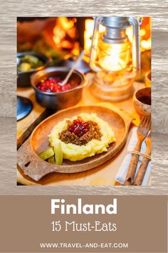 a wooden plate topped with mashed potatoes and cranberries next to a lantern