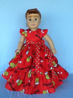 a doll is wearing a red dress with green apples on it and the words shrapsburgs are in black letters