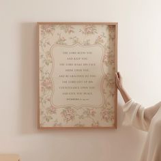 a woman is holding up a framed poem