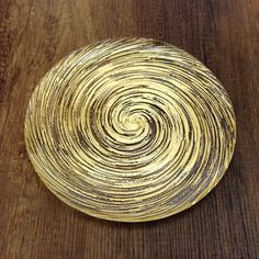 a wooden table topped with a yellow and black plate on top of it's surface