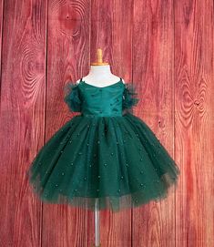 Little Darln Boutique  Our enchanting Knee Length flower girl dresses are sure to turn heads! This beautiful elegant dress is handmade, the bodice consists of Hunter Green satin with a layer of pearl tulle, followed by spaghetti straps and of the shoulder tulle sleeves. The back of the dress has a zipper for closure. The skirt consists of 4 Hunter Green layers of tulle with the top layer consisting of pearl beads. The fifth layer is made of lining with crinoline for fullness.  This dress is perfect for any occasion!  Dress Is Pictured with a petticoat NOT INCLUDED https://www.etsy.com/listing/1316417982/white-knee-length-petticoat-wedding?click_key=41cb8b0ae4587efa582b0a433f3f5e0cde12aec0%3A1316417982&click_sum=af1df37b&ref=shop_home_active_1 Visit our store, more items to come!  https://w Elegant Tulle Holiday Dress For Festive Occasions, Elegant Holiday Tutu Dress For Pageant, Elegant Tutu Dress For Holiday Pageants, Elegant Festive Tulle Princess Dress, Holiday Tulle Ball Gown For Pageant, Holiday Princess Ball Gown For Pageants, Holiday Princess Pageant Dress For Wedding, Holiday Princess Style Wedding Pageant Dress, Princess Ball Gown For Pageant Holiday