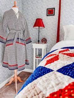 a bed room with a neatly made bed next to a night stand and a lamp