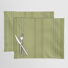 two placemats with forks and knife on them, one green striped table cloth