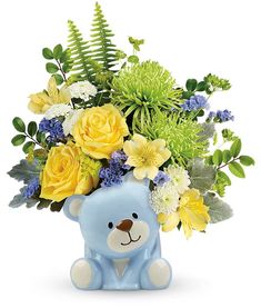 a blue teddy bear with yellow and white flowers