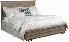 a bed with two drawers underneath it and pillows on the headboard, along with a throw pillow