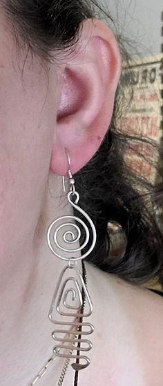 a close up of a person wearing some kind of earring with wire attached to it