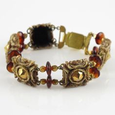 Henry Perichon, a French jewelry designer, created this stunning resin link bracelet adorned with amber-colored glass beads and metallic stones. He revolutionized the plastic jewelry industry with his "rhodoid" invention,  which he extensively used to craft his innovative jewelry. The scored resin setting produces extraordinary examples of costume jewelry, and the bracelet is signed "Henry" on a small gilt metal tag at the clasp. Measurements: The bracelet's total length is 8.87 in (22.5 cm) - w Vintage Gold Glass Bracelets, Vintage Resin Bracelet, Victorian Collectible Bracelet, Luxury Vintage Gold-tone Bracelets, Gold-tone Metal Chain Link Charm Bracelet, Resin Bracelet, French Jewelry, Metal Tags, Plastic Jewelry