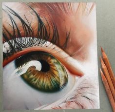 an eye is shown with colored pencils next to it