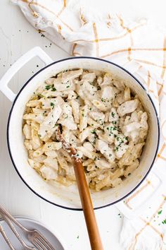 a pot filled with pasta and chicken on top of a table