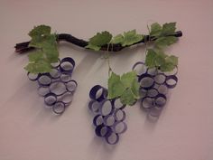 some grapes are hanging from a vine on the wall