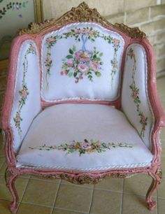 a pink and white chair sitting on top of a tile floor