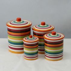 three colorful striped canisters with lids