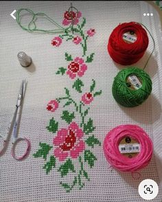 needle and thread laid out on top of a table with scissors, yarn and needles