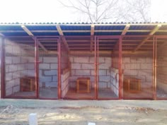 several cages are set up in front of a building with metal bars on the sides