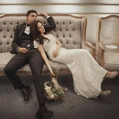 a bride and groom sitting on a couch