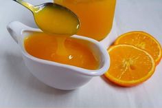 orange juice being poured into a small white bowl