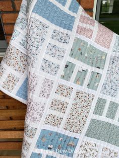 a blue and white quilt hanging on the side of a building