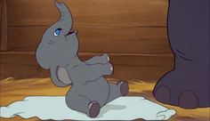 an elephant is sitting on the floor next to a big foot in disney's dumbo