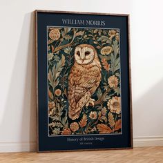 an owl sitting on top of a wooden floor next to a framed wall art piece