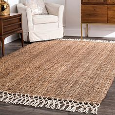 a living room area with a chair and rug on the floor, next to a dresser