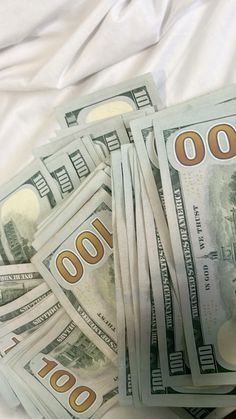 five hundred dollar bills are stacked on top of each other in front of white sheets