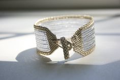 a close up of a bracelet on a table with sunlight coming through the window behind it