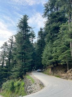 an empty road surrounded by trees and rocks