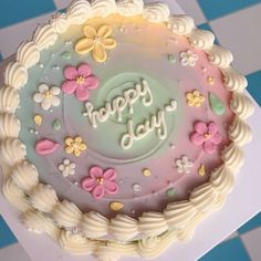 a birthday cake with flowers and the words happy day written in frosting on it