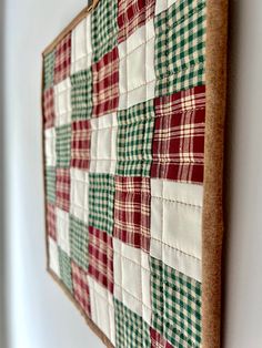 a close up of a piece of cloth hanging on a wall with a wooden frame