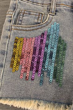 a pair of jeans with colorful sequins on them