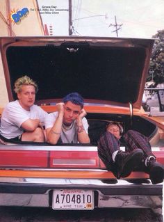 two men sitting in the trunk of a car