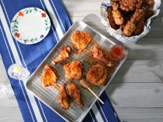 some fried food is sitting on a tray next to a plate with dipping sauces