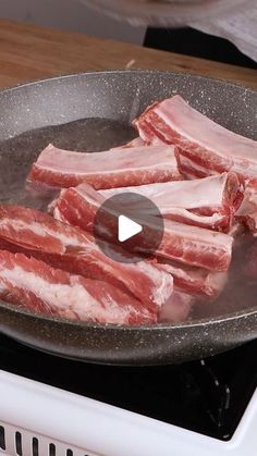 raw meat cooking in a frying pan on top of an electric stove burner