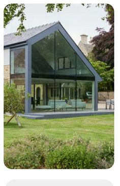 a large glass house sitting on top of a lush green field