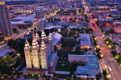 an aerial view of a city at night with tall buildings and street lights in the foreground