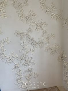 the wall is decorated with white flowers and leaves