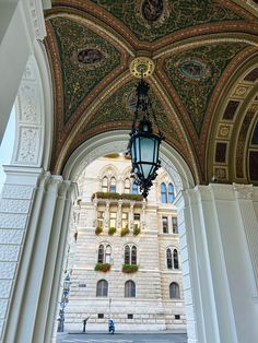 an ornate archway with a light hanging from it's ceiling in front of a building