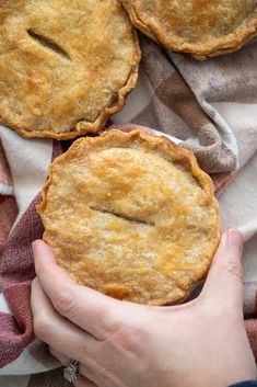 two pies with faces drawn on them are being held by someone's hands