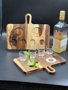 a wooden cutting board with glasses and bottles on it, next to a bottle opener