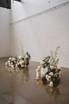 white flowers and candles are arranged on a table