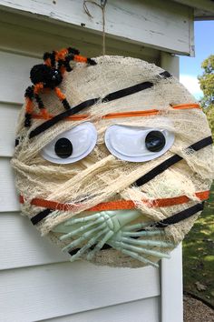 a homemade halloween mask hanging on the side of a house