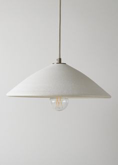 a white light hanging from a ceiling fixture with an effile bulb in the center