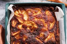 a square casserole dish with sliced bananas on top and napkins around it