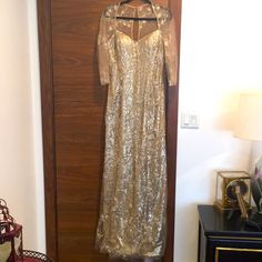 a gold dress hanging on a wooden door