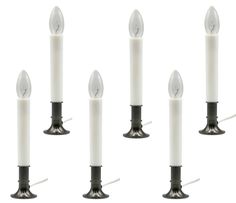 six white candles are lined up with one candle in the middle and four on each side