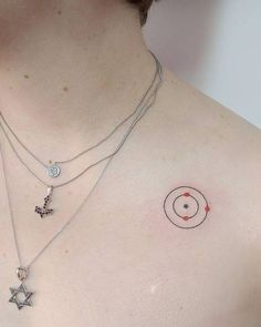 a woman's chest with three different necklaces on her left shoulder and one has a star